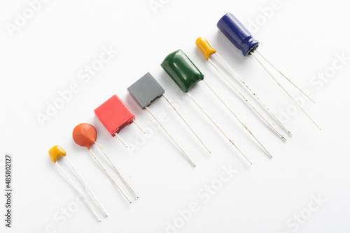 Different types of ceramic, film, tantalum and electrolytic capacitors on white background
