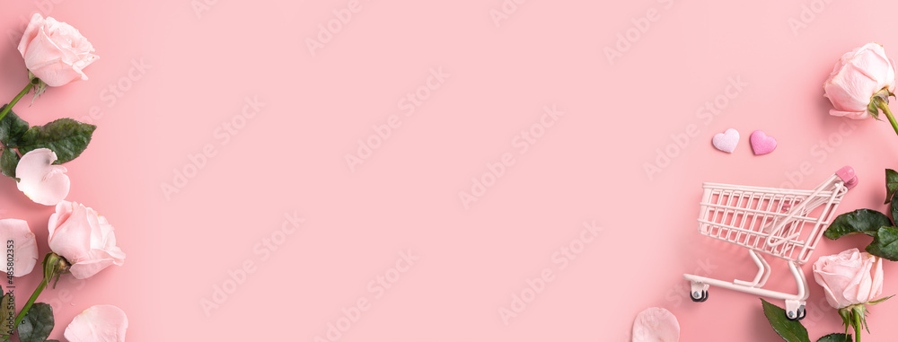 Valentine's Day shopping design concept background with pink rose flower and cart on pink background. Valentine's Day shopping design concept background with pink rose flower and cart on pink background.