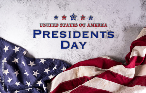 Happy presidents day concept with flag of the United States and the text on dark stone background.