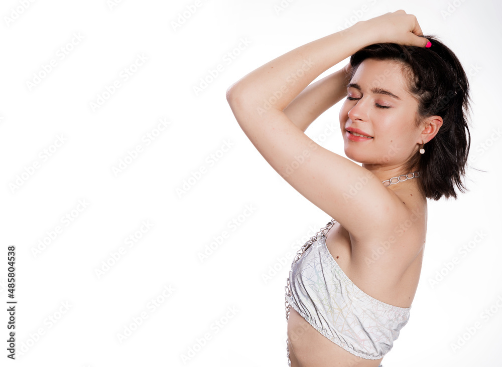 A beautiful woman posing in a jewelry bra with chains and blue jeans isolated on white background. Mockup for party or dance concept with space for text A beautiful woman posing in a jewelry bra with chains and blue jeans isolated on white background. Mockup for party or dance concept with space for text