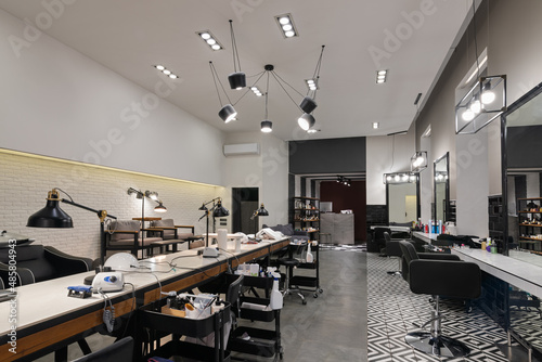 Quadro su tela Modern interior of the beauty salon which consist of nail salon and barbershop with black lamps and concrete wall