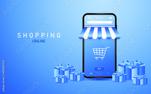 Online shopping on smartphone with shopping cart icon on screen with gift boxes lying around on blue background.
