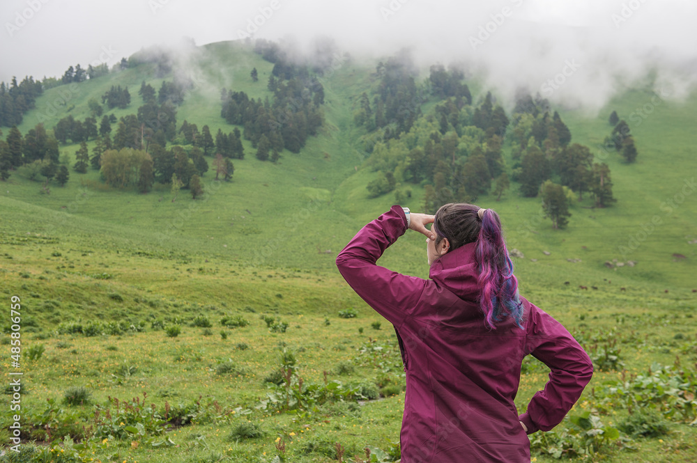 Woman with colorful hair looking on foggy valley