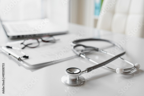 Foto Doctor office desk, workplace of physician therapist with stethoscope closeup, Health care, medicine concept