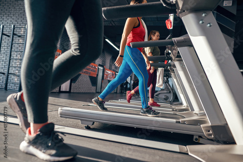 Partial of multiracial girls running on treadmill
