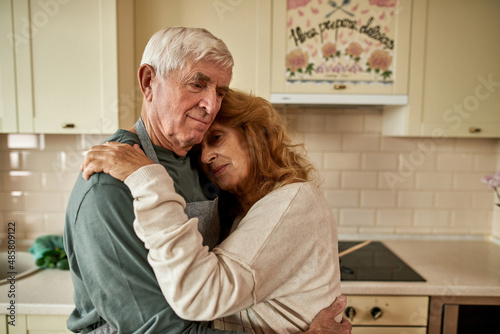 Senior caucasian couple hugging each other at home