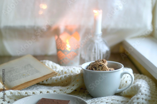 Wallpaper Mural Plate with almond chocolate bar, mug with chocolate chip cookies, open book, reading glasses, soft blanket and lit candles. Hygge at home. Selective focus. Torontodigital.ca