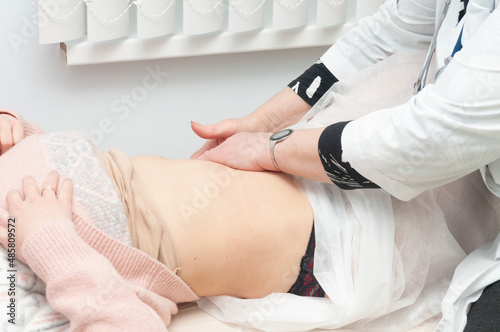 Φωτογραφία Close-up of the doctor's hands and the girl's stomach