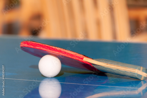 Tennis racket and ball on the table.