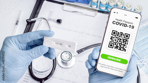 Vaccination certificate. Medical equipment with Coronavirus vaccine certificate on phone screen, healthcare charts, syringe and doctor stethoscope on hospital background. Concept of immunity passport.