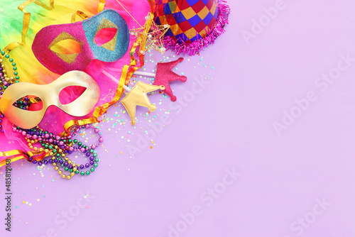 Holidays image of mardi gras masquarade masks over purple background. view from above