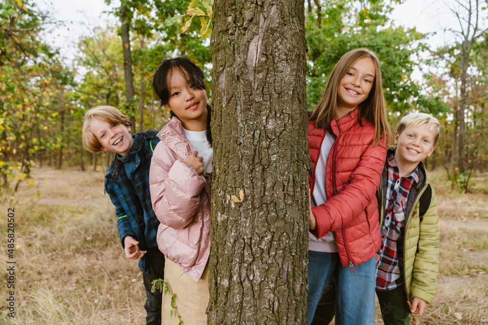 Multiracial four teenagers smiling during hiking in forest Multiracial four teenagers smiling during hiking in forest