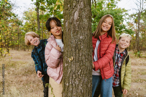 Fotografie Multiracial four teenagers smiling during hiking in forest