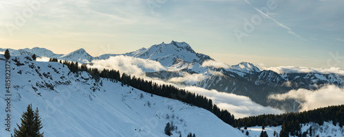 Dramatic snowy winter mountain landscape with low misty clouds and forests at the ski resort of Morzine in the Alps Mountain Range of France, Europe