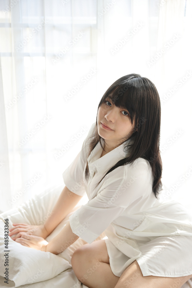 Beautiful young woman waking up in the morning at white bedroom Beautiful young woman waking up in the morning at white bedroom