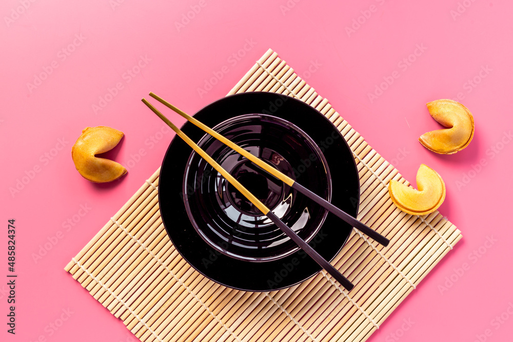 Asian style tabble place setting with fortune cookies and golden chopsticks Asian style tabble place setting with fortune cookies and golden chopsticks