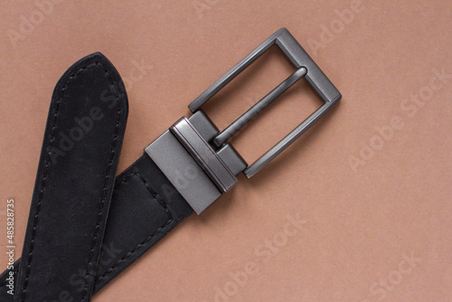 black leather belt on a beige background
