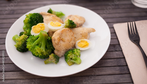 chicken breast with broccoli and quail eggs on plate for healthy dinner