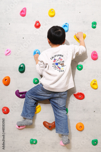 自宅の壁でクライミングを楽しんでいる男の子。