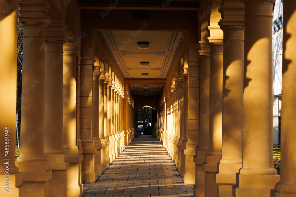the columns of the walkway in the Hessinpark in Augsburg shine in the golden sunlight