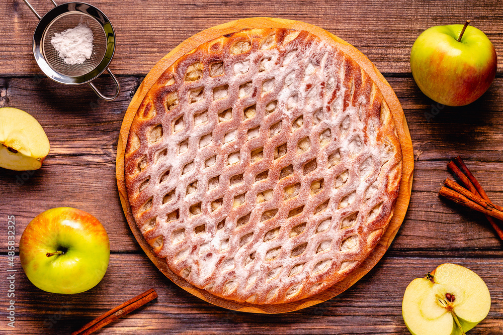 Homemade apple pie with cinnamon on a wooden background. Homemade apple pie with cinnamon on a wooden background.