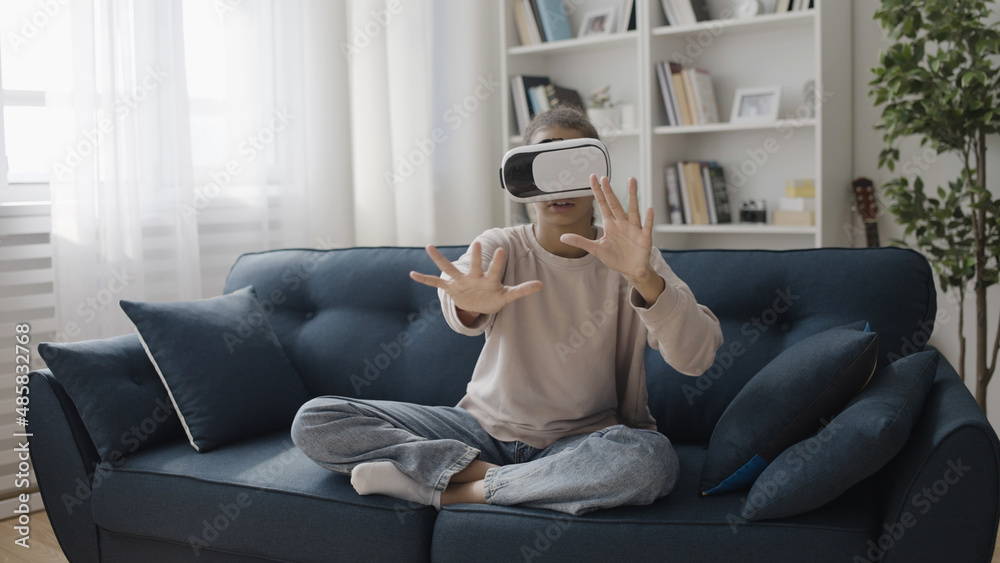 Excited teenager in vr goggles touching space with hands, playing simulation game, augmented reality Excited teenager in vr goggles touching space with hands, playing simulation game, augmented reality