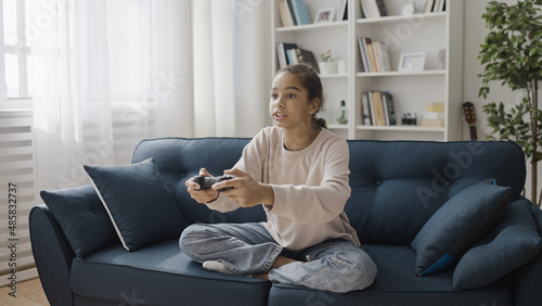 Free Download Teen girl playing video game at home, pressing buttons on joystick, modern technology - GFXLoad