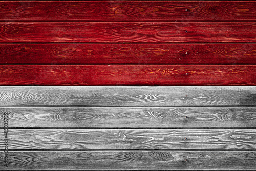 The national flag of Indonesia is painted on a camp of even boards nailed with a nail. The symbol of the country.