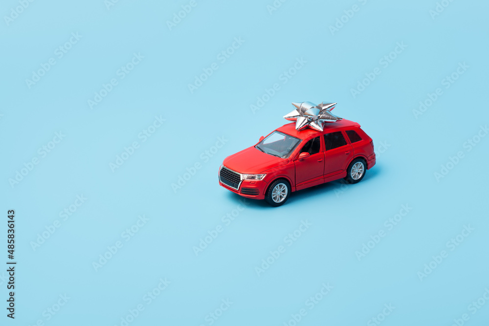 Fototapeta premium Present, gift red car on isolated blue background with copyspace. Mockup. Flatlay. Business concept