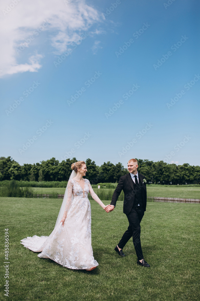 Walking the bride and groom outdoors. Beautiful summer photo session in nature.
