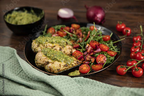 Chicken breast baked in nut and parsley pesto with red onion salad photo