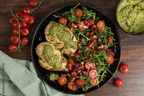 Chicken breast baked in nut and parsley pesto with red onion salad photo