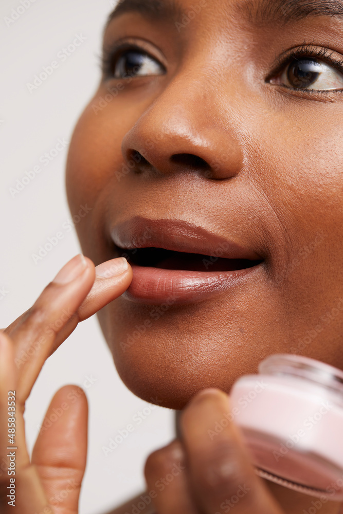 Close-up of woman applying lip balm - obrazy, fototapety, plakaty 