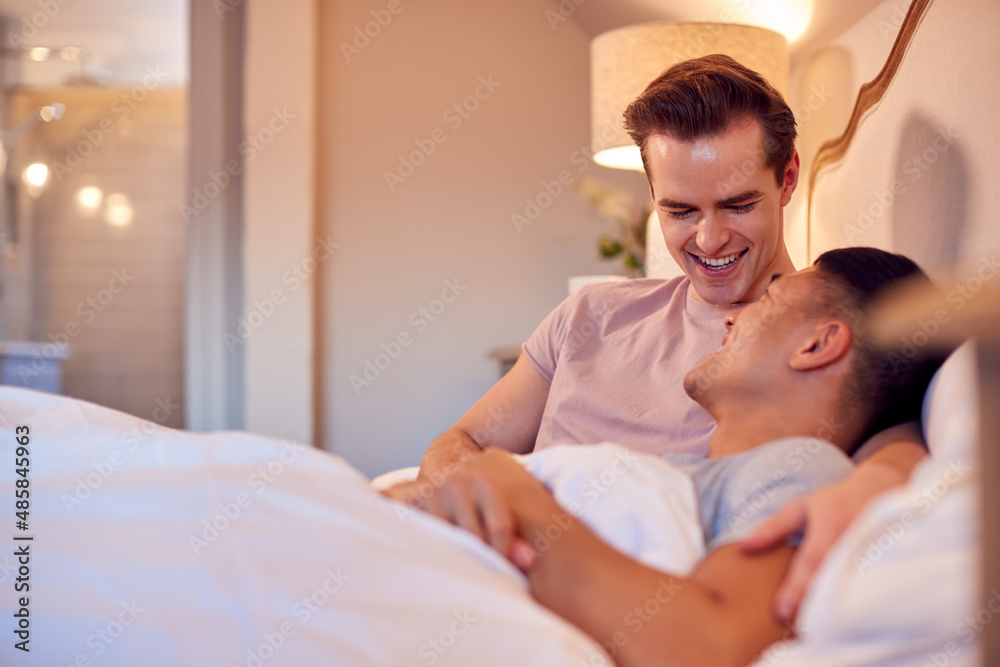 Loving Same Sex Male Couple Lying In Bed At Home Hugging Loving Same Sex Male Couple Lying In Bed At Home Hugging