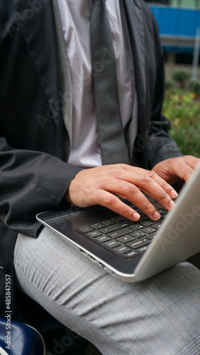 Midsection of business man using laptop
