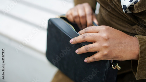 Woman reaching into purse, close up