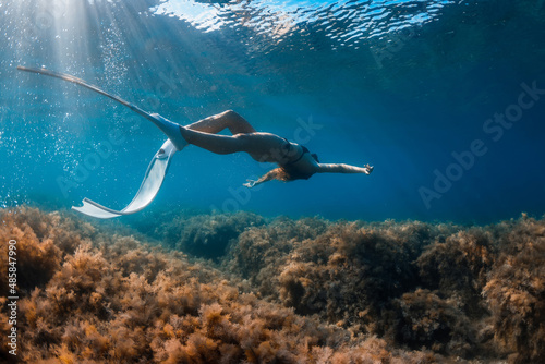 Free diver with white fins posing underwater. Freediving with young girl