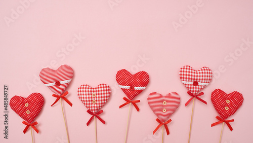 Valentine's Day composition with textile love hearts on pink background