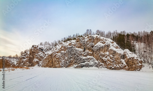 Winter landscape with a large stone from a frozen river