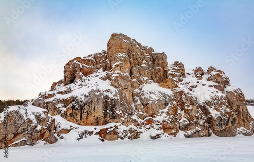 Winter landscape with a large stone from a frozen river