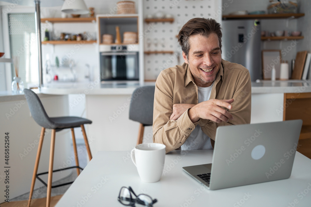 Smiling middle-aged freelancer having a video call meeting early in the morning. Smiling middle-aged freelancer having a video call meeting early in the morning.