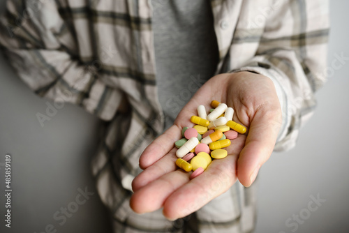 A hand holds an assortment of pills and vitamins close-up. Effective drugs, modern pharmacy for the body and mental health. The concept of healthcare, medicine, pharmacies, disease prevention