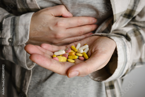 A hand holds an assortment of pills and vitamins close-up. Effective drugs, modern pharmacy for the body and mental health. The concept of healthcare, medicine, pharmacies, disease prevention