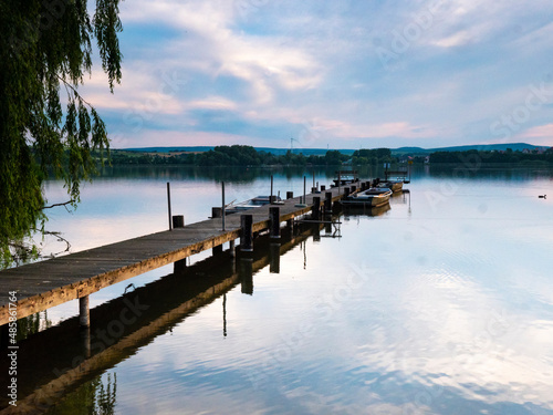 A long landing stage with a few rowing boats in the evening mood © Axel Jahnke