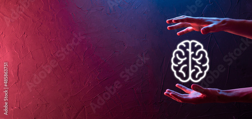 Male hand holding brain icon on neon red,blue background. Artificial intelligence Machine Learning Business Internet Technology Concept.Banner with copy space