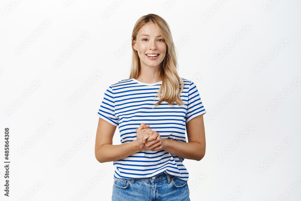 People concept. Stylish modern girl, 25 years old, standing in assistant helpful pose, ready to offer help, listening to customer and smiling, standing over white background People concept. Stylish modern girl, 25 years old, standing in assistant helpful pose, ready to offer help, listening to customer and smiling, standing over white background