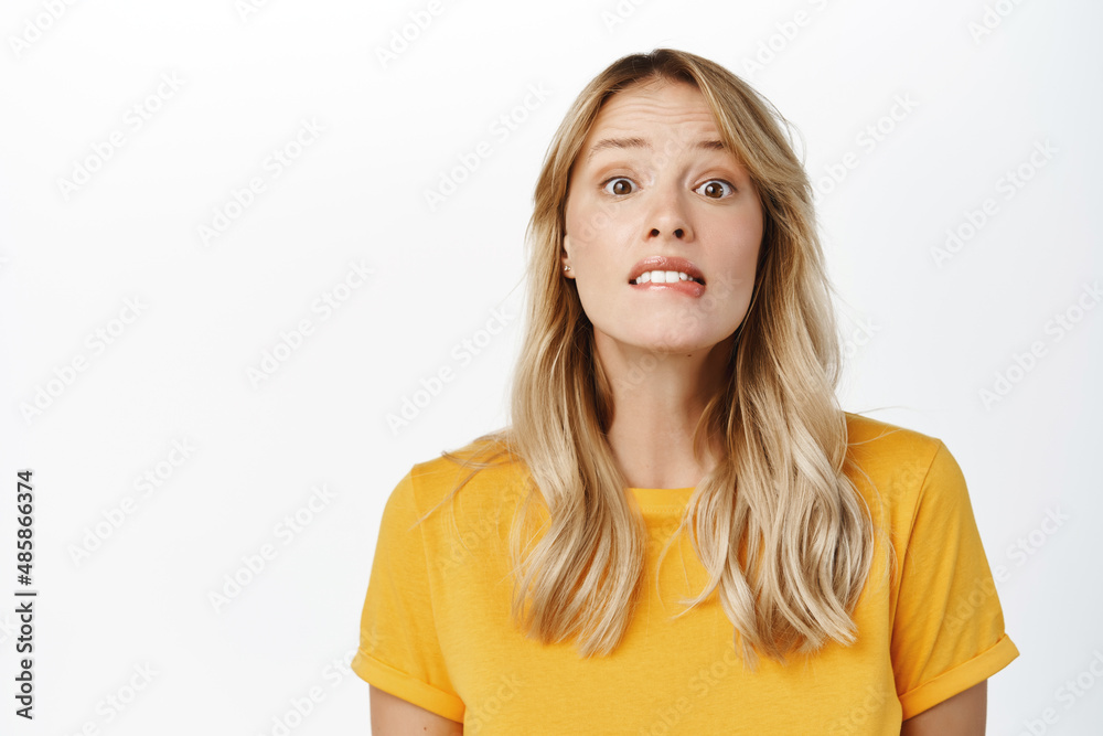 Image of hopeful cute blond girl yearning, want smth, look with desire and hope, stands in yellow t-shirt over white background Image of hopeful cute blond girl yearning, want smth, look with desire and hope, stands in yellow t-shirt over white background