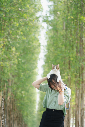 asian woman happy during travel and play with her cat on spring season © tickcharoen04
