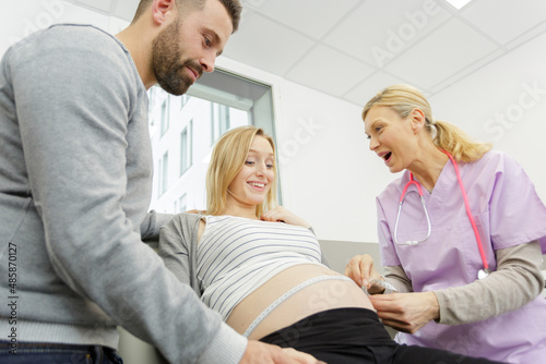 a pregnant woman measuring belly © auremar