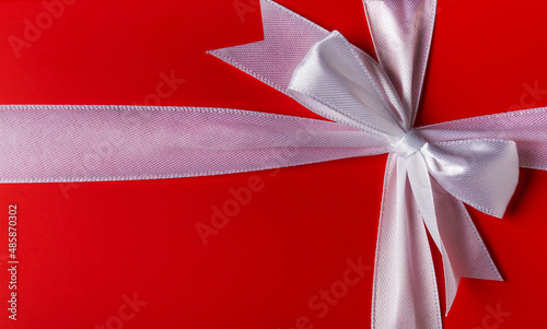 Big red gift box with a beautiful white bow.